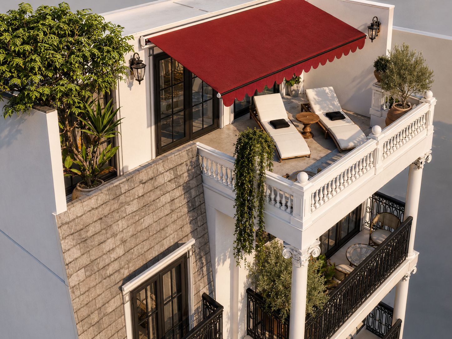 Terraza con toldo rojo, tumbonas y jardinera con olivo