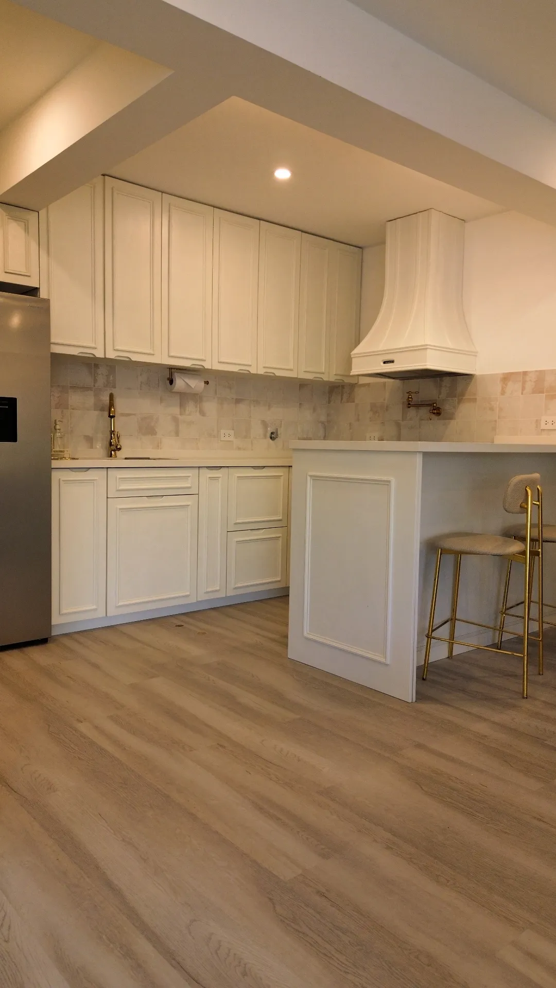 Cocina del Flat 501 en Pizarro 320 con isla central, cabinetería blanca y acabados clásicos